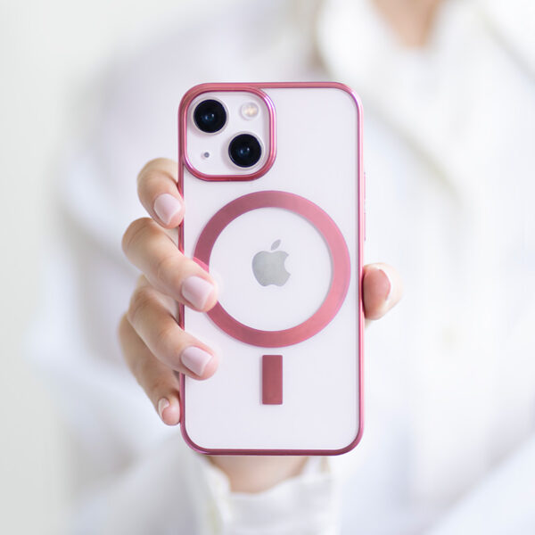 Foto på tjej hand som håller fram en MagSafe telefonskal i rosa